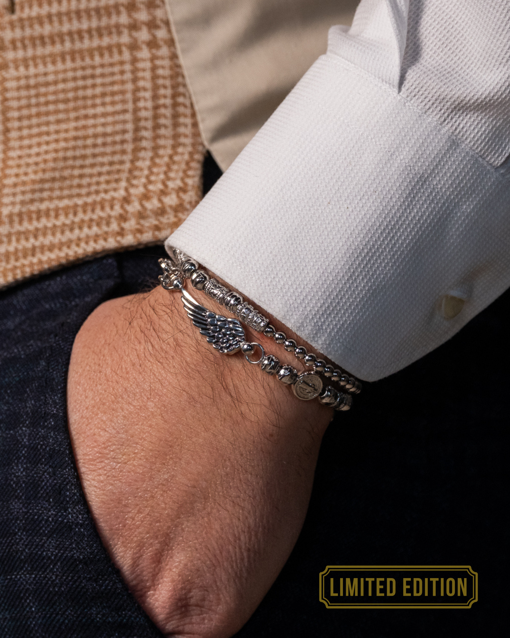 Doppelt drehbares Herrenarmband in Silber mit kleinen und großen Kugeln und individuellem Flügelanhänger